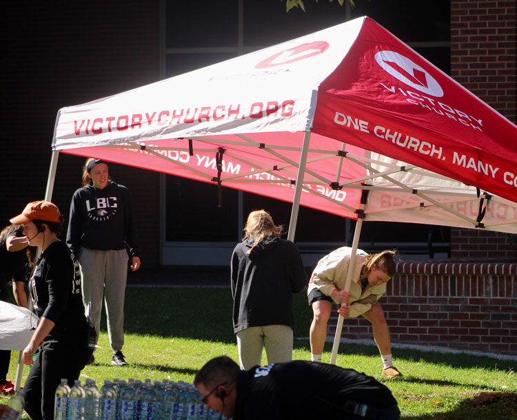 students setting up a canopy tent for an event
